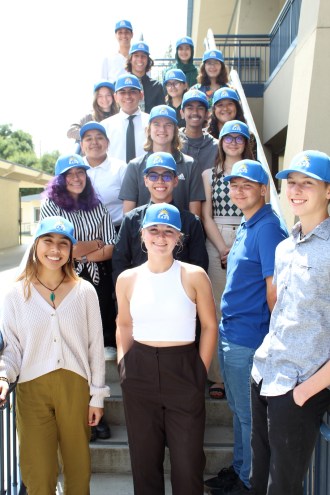 a group of young people pose for a photo on the stairs