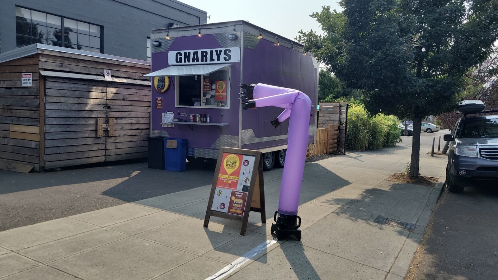 Purple food truck with a sign outside