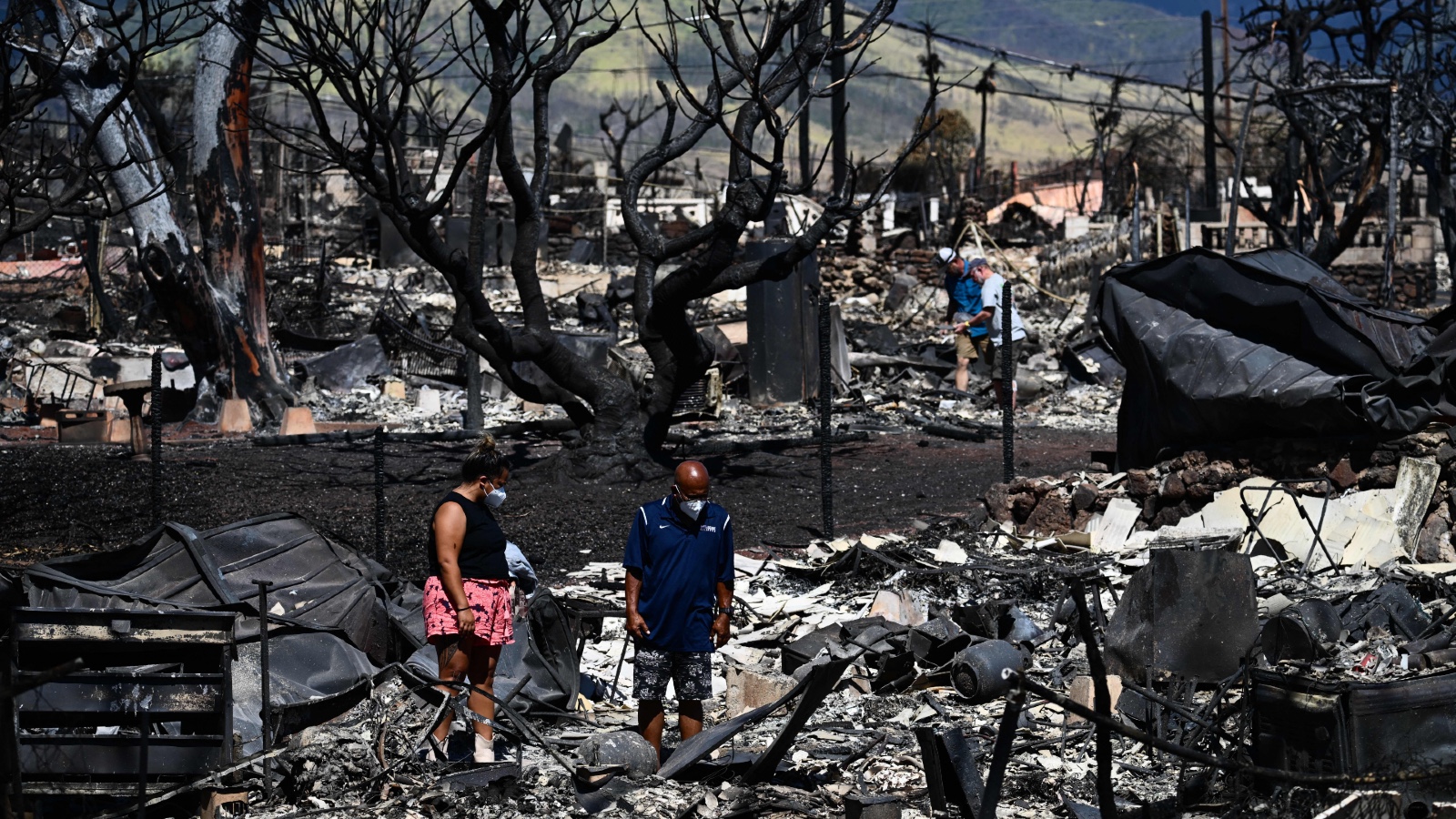 Two survivors search for belongings in wreckage in the historic town of Lahaina after wildfires broke out across Maui.