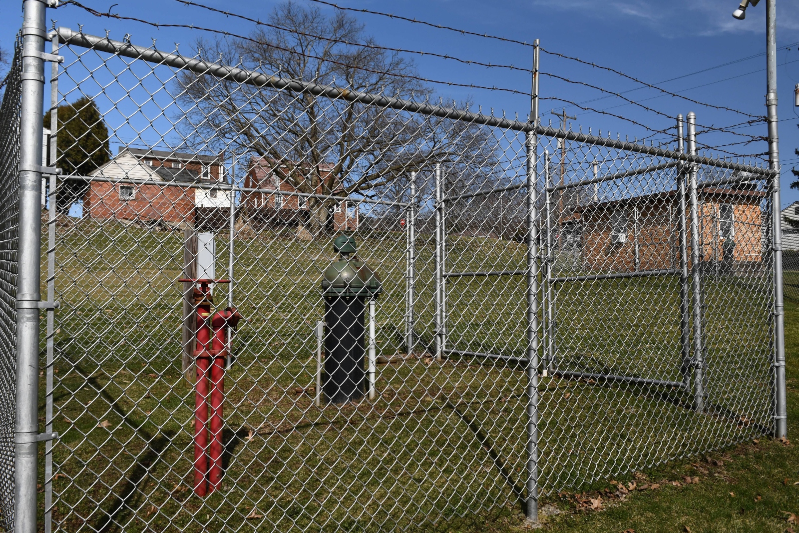 A chain-link fence surrounds a well.