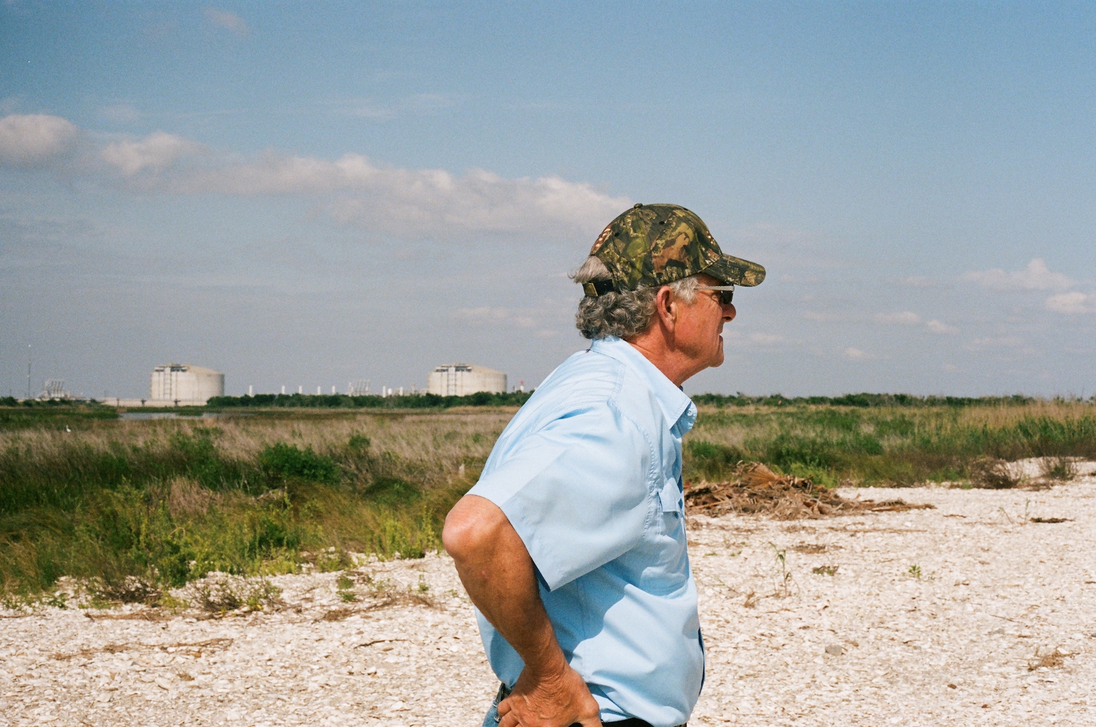 a man in a baseball cap and blue shirt looks away from the camera