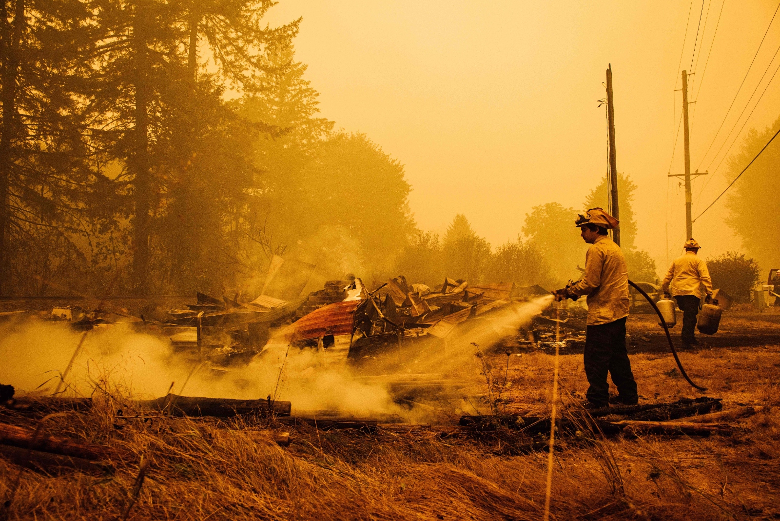 Oregon firefighters put out embers in Mill City, Oregon, on September 10, 2020, as they battle the Santiam Fire, which ignited in part thanks to Pacificorp's power infrastructure.
