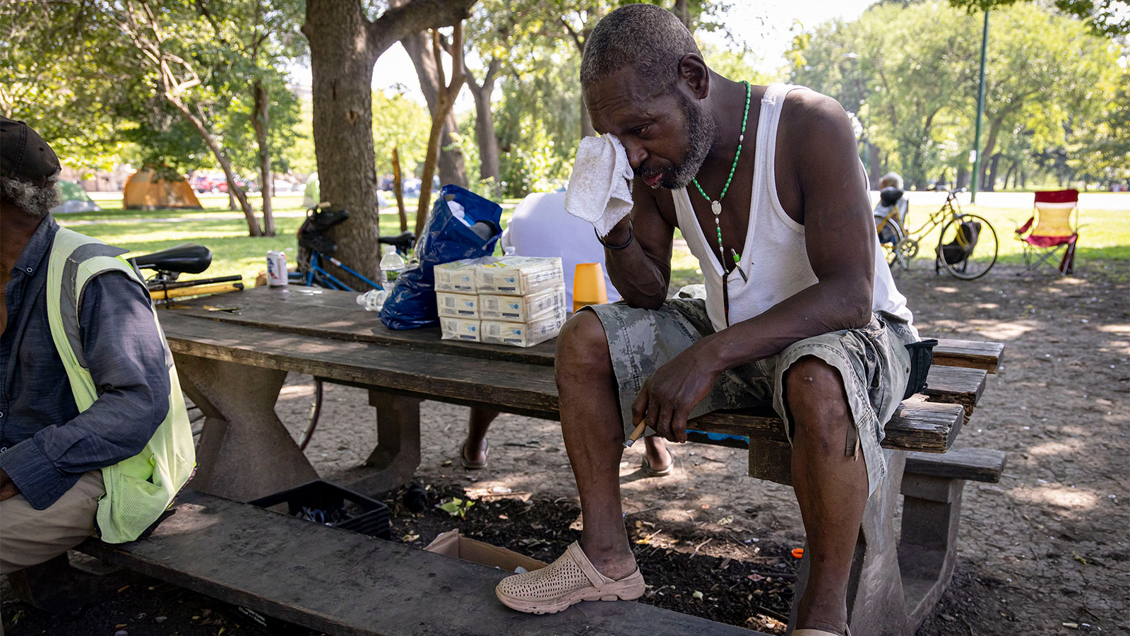 A man wipes sweat from his face in a park in Chicago where temperatures hit 99 degrees