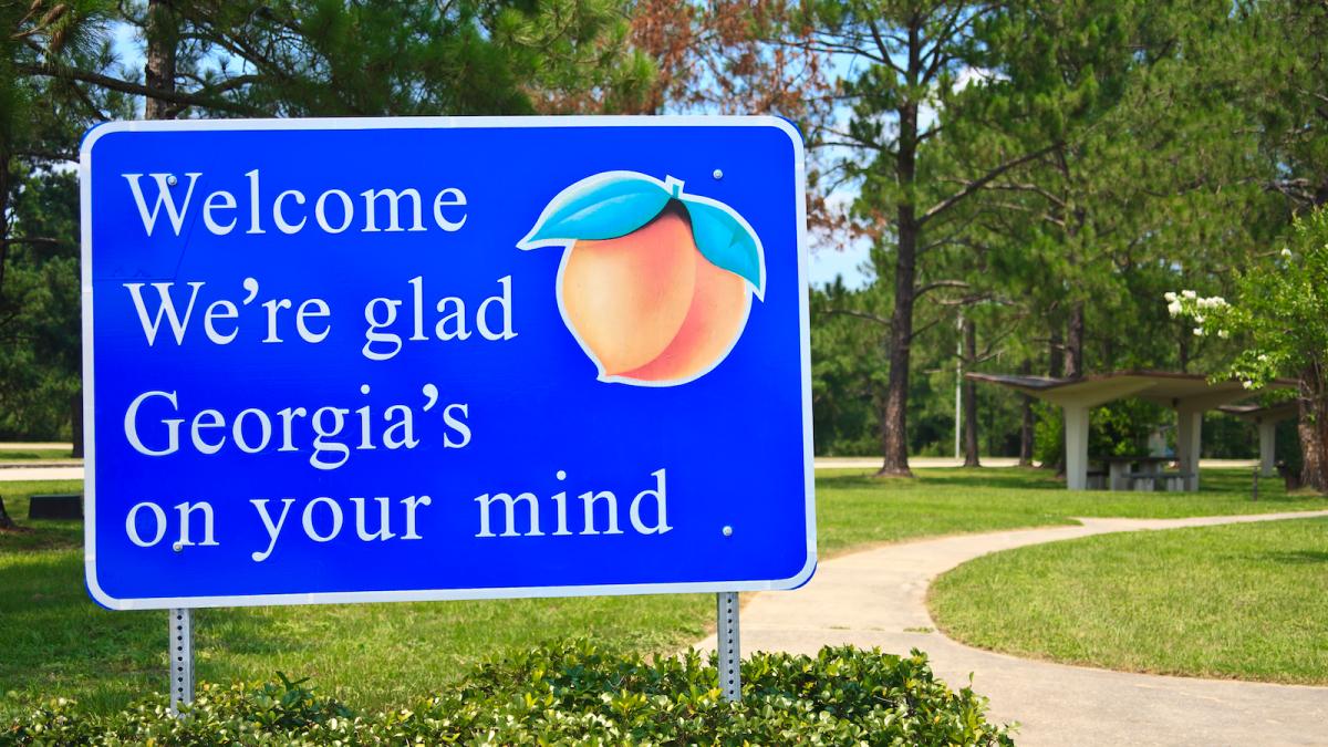 A blue sign that reads "Welcome we're glad Georgia's on your mind."
