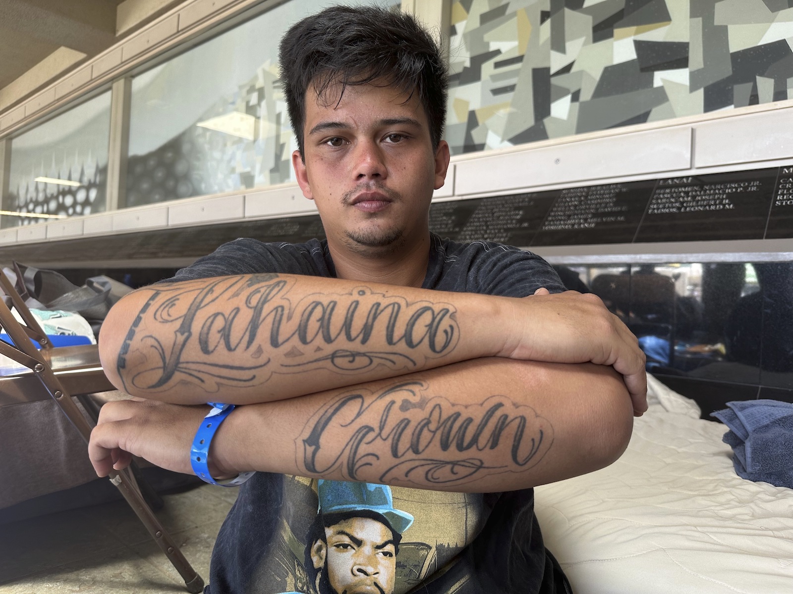 a young man shows his forearms which are tatooed with "Lahaina Grown"