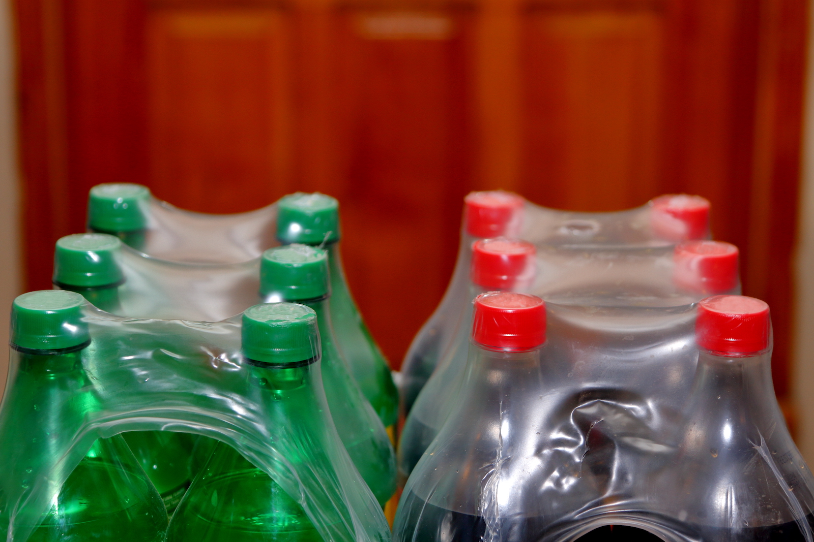 green plastic bottles and clear plastic bottles with plastic wrap on top