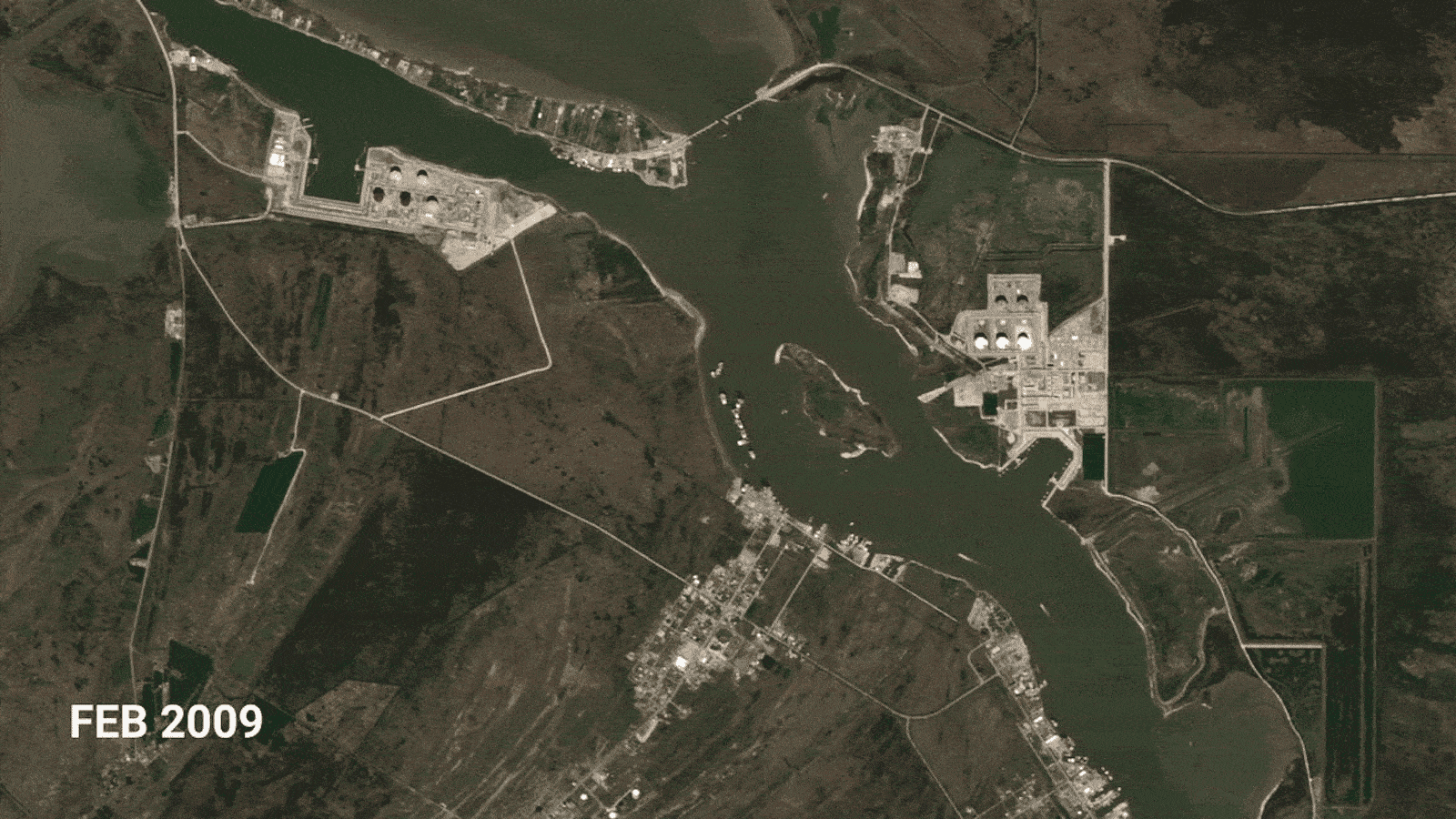 a satellite view of a river with two facilities being built over time