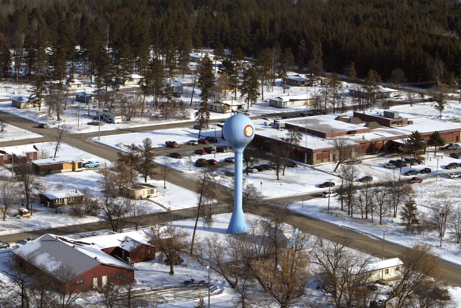 a neighborhood covered in snow with water tower