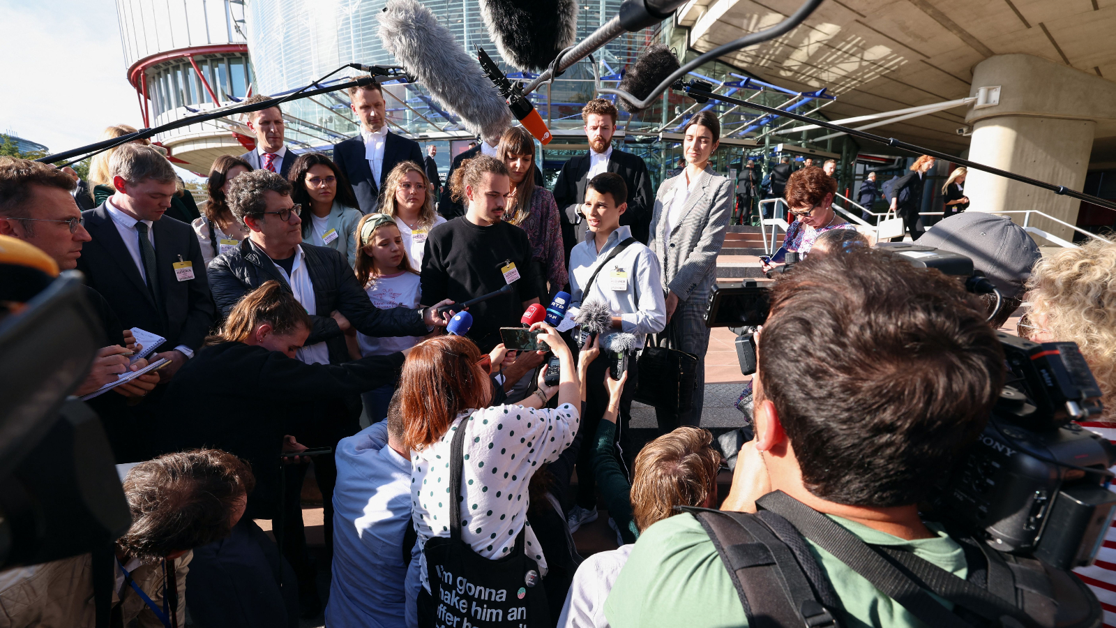 Young Portuguese citizens address media outside the European Court of Human Rights (ECHR) after a hearing in a climate change case involving themselves against 32 countries, in Strasbourg, eastern France, on September 27, 2023.