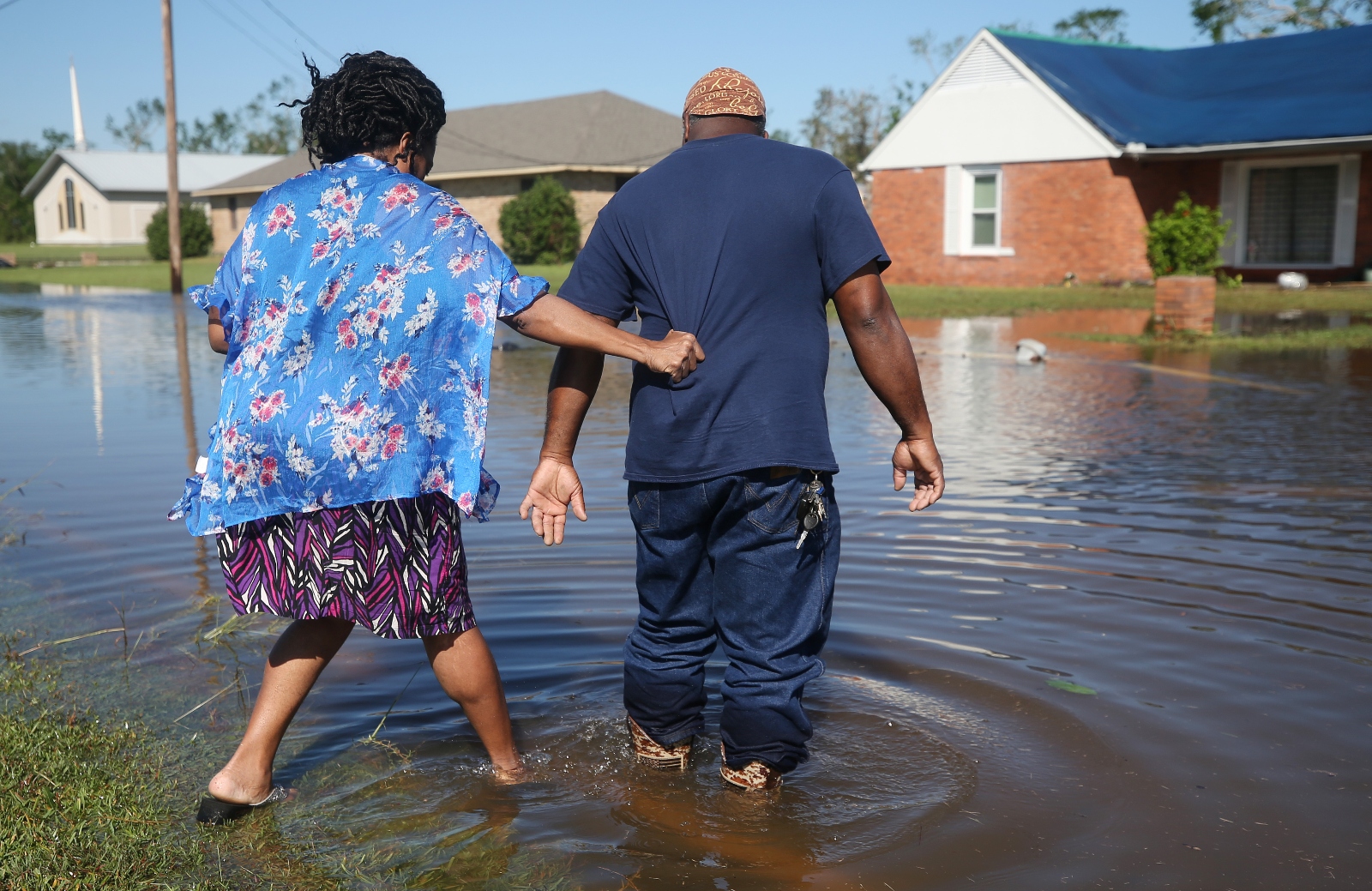 Patrick King and Soncia King walk through flood waters from Hurricane Delta toward their home after Hurricane Laura.