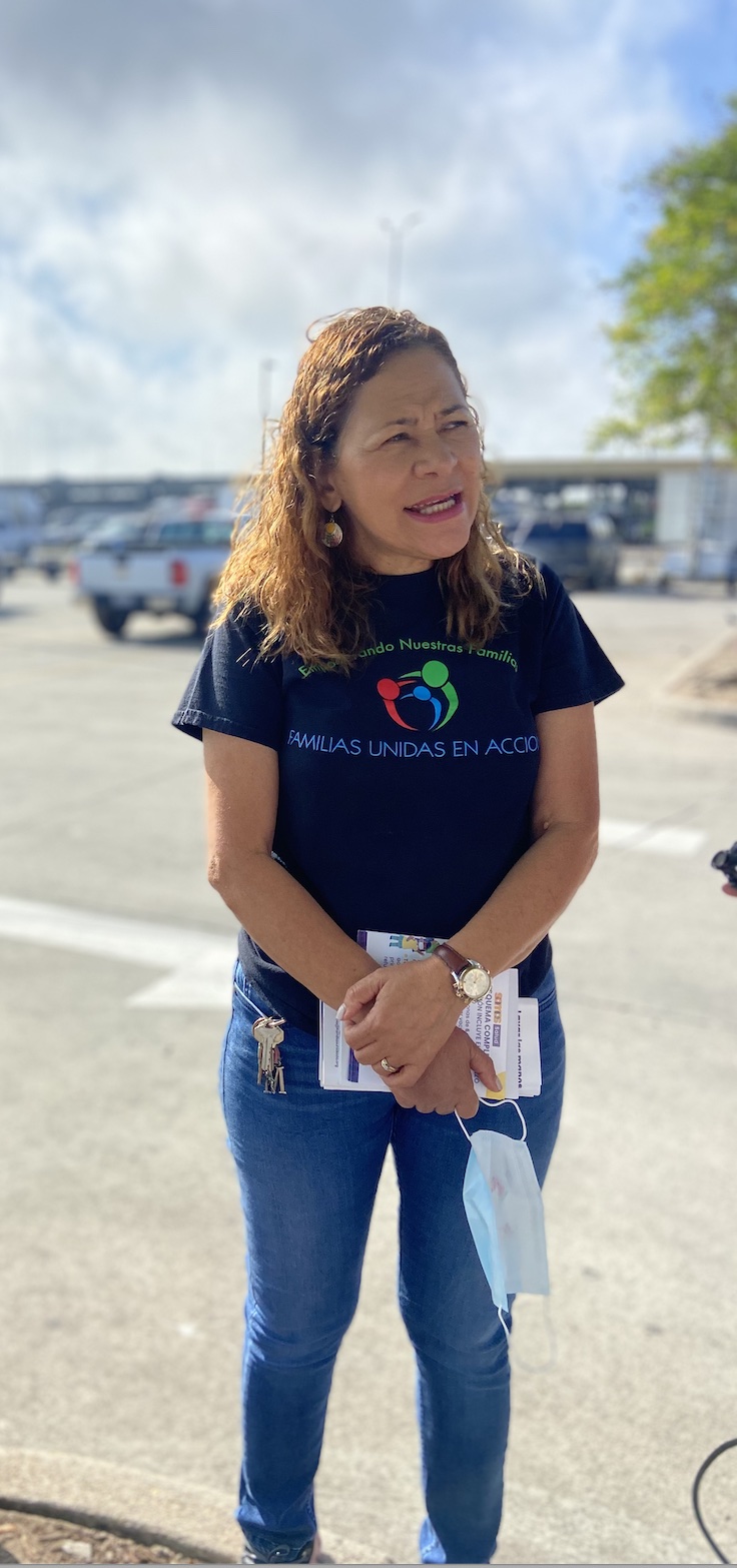 Miriam Romero, a community health worker with Familias Unidas en Acción, wears the organization’s navy T-shirt and jeans, and speaks with disaster restoration workers while holding leaflets and a mask. Romero handed out free NIOSH-approved masks and leaflets on workplace toxins to day laborers waiting for a job in a Lowe’s parking lot in New Orleans.