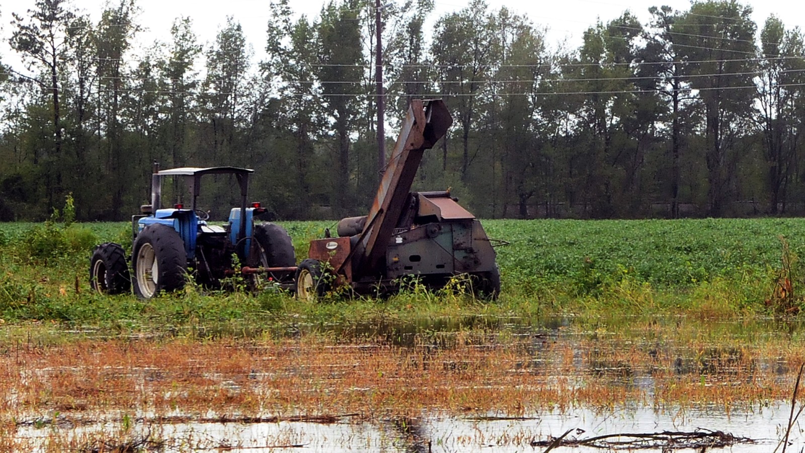 A tractor stuck in a flooded field.