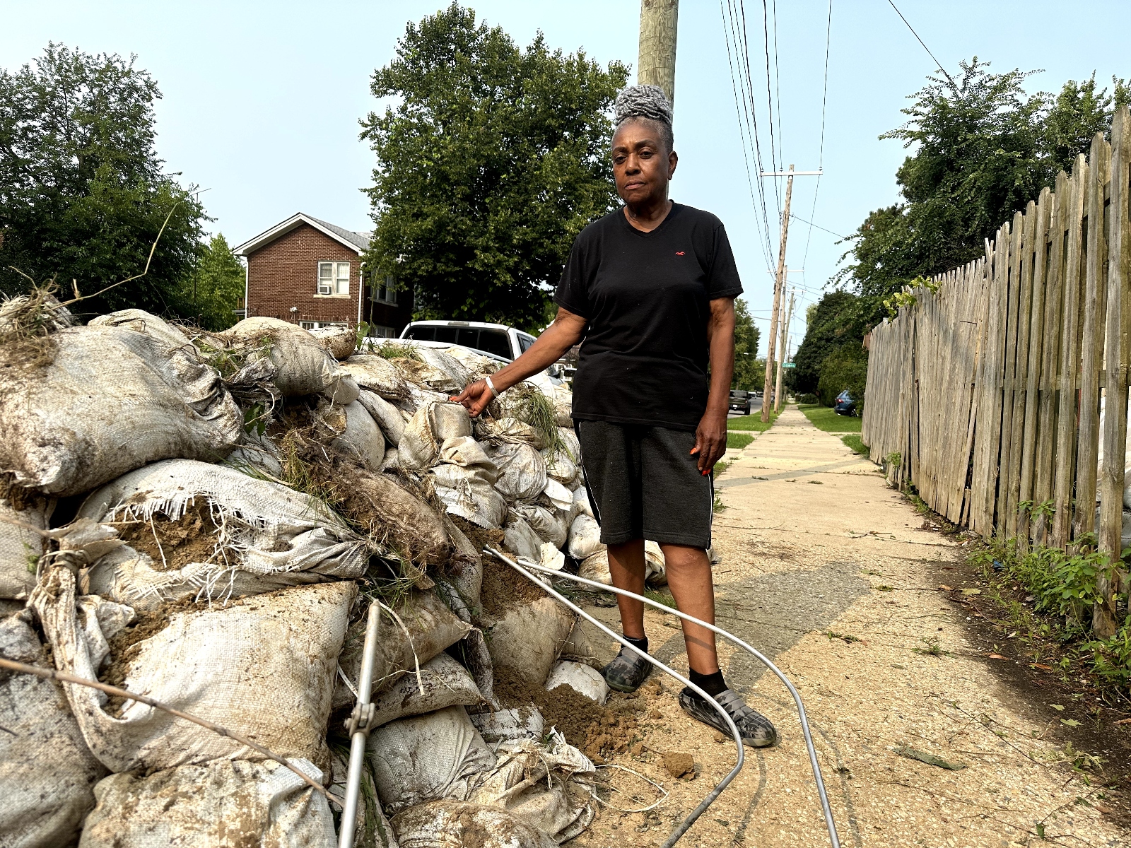 Wilma Price standing by sandbags Detroit installed to prevent flooding, which did not work