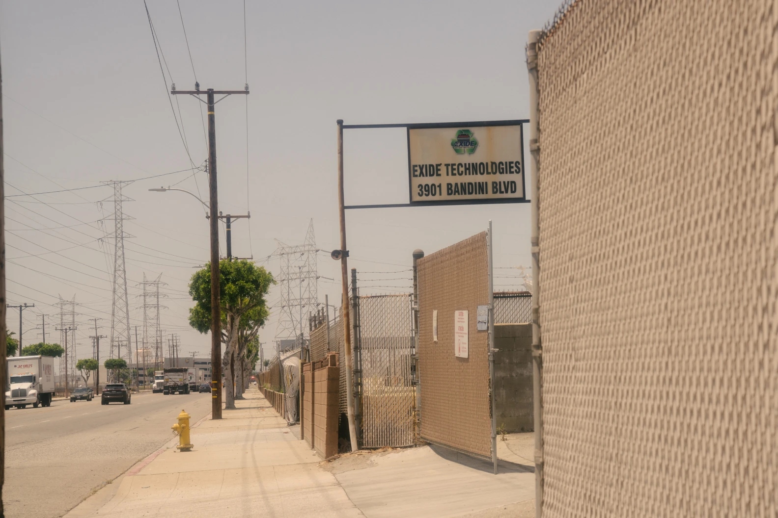 A sign that reads Exide Technologies on an empty city street.