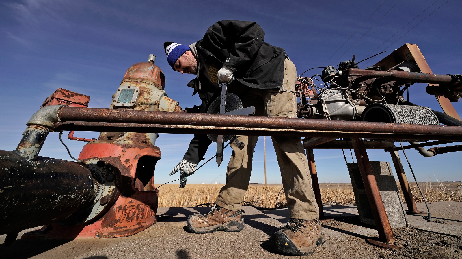 A researcher measures water levels in an irrigation well near Marienthal, Kansas. Water levels in the state's Ogallala Aquifer have been declining for decades.