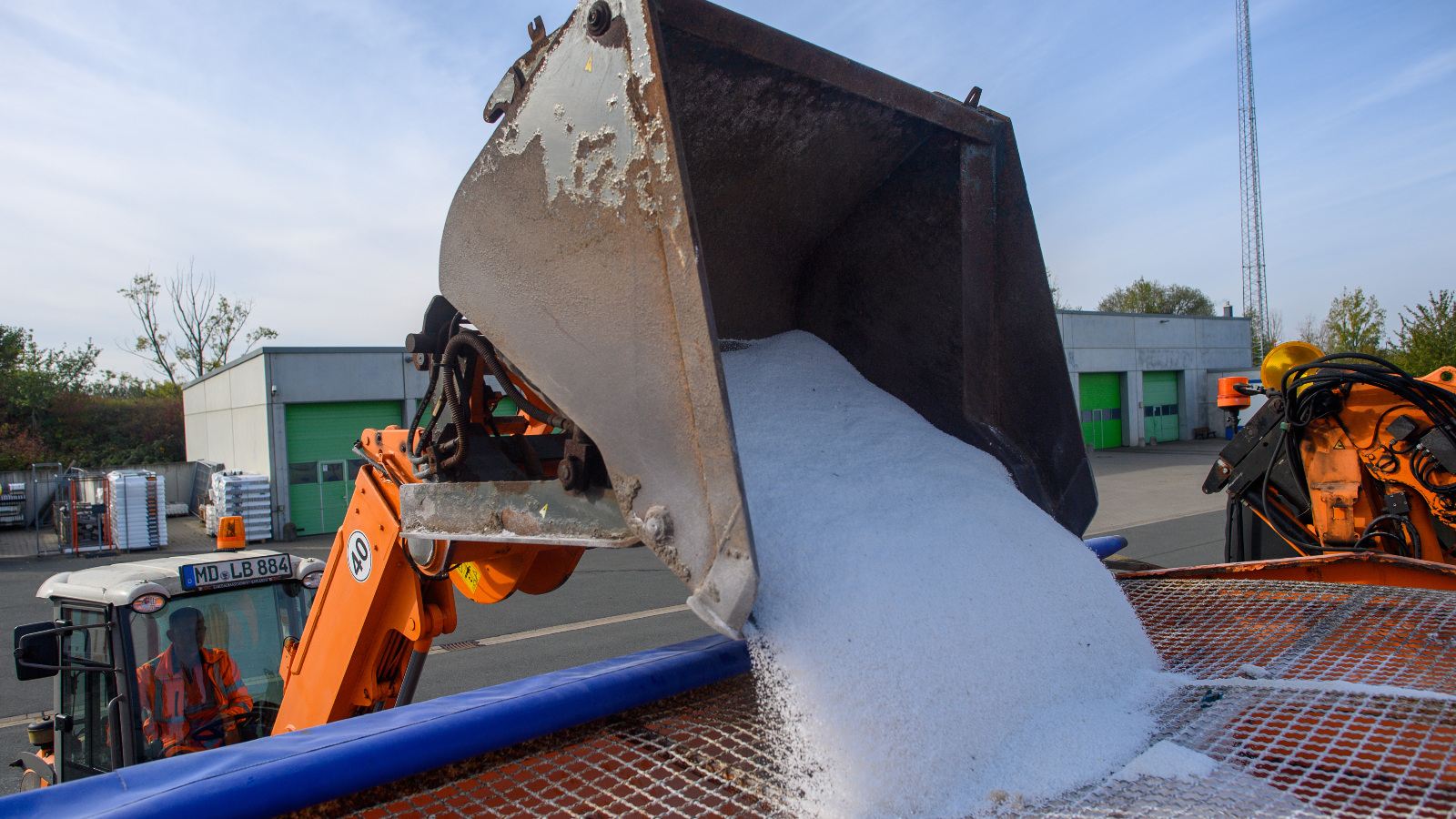 Photo of an excavator pouring a large volume of salt