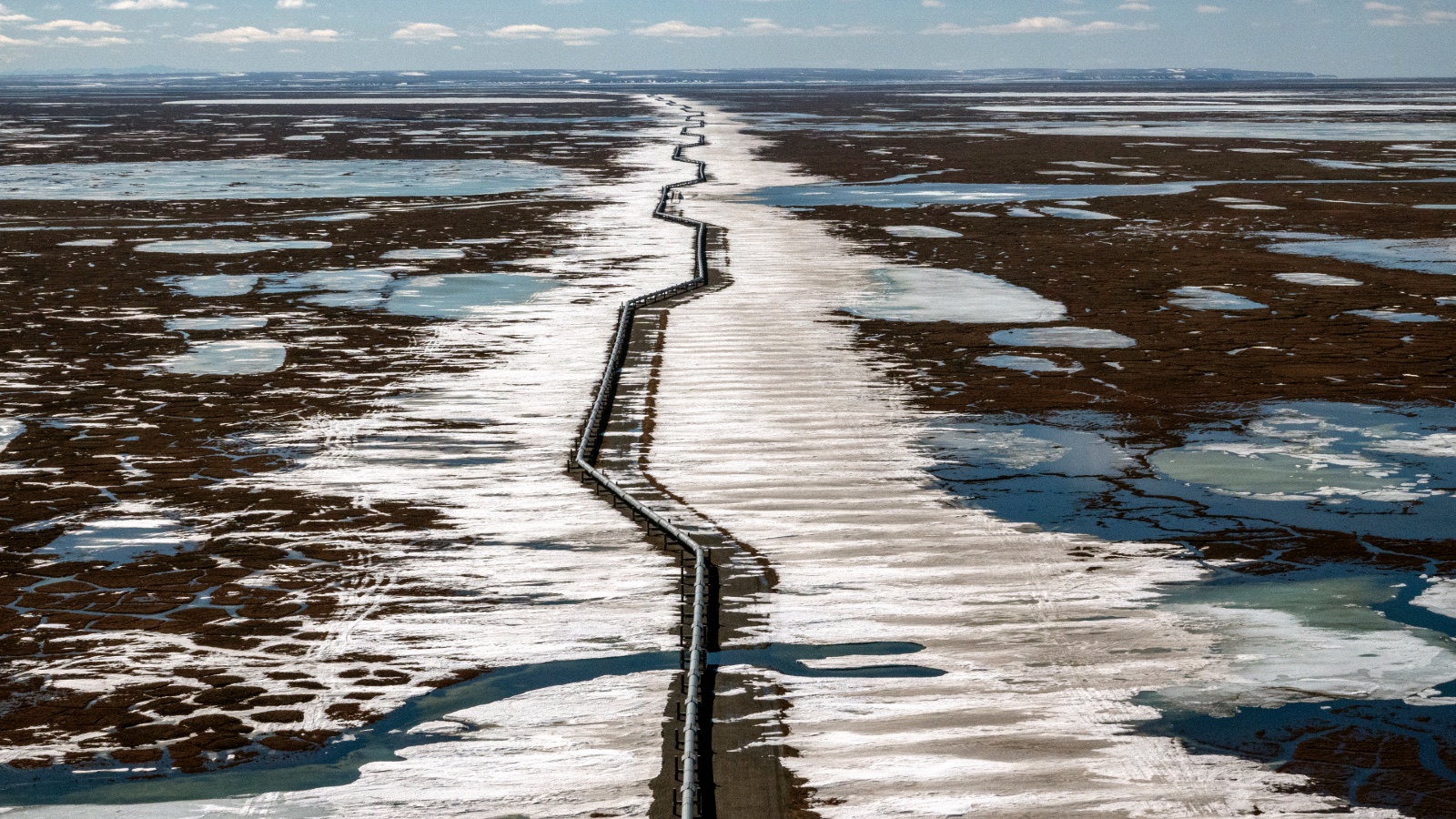 An oil pipeline stretches across the tundra in Alaska.