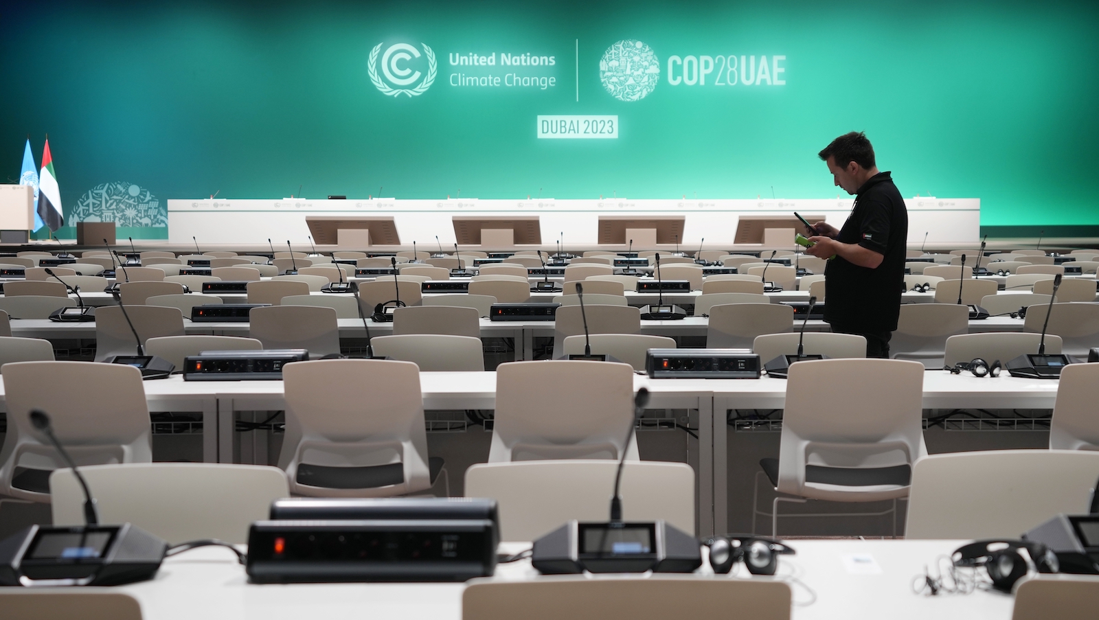 A worker sets up in a room a full of empty chairs and microphones ahead of the COP28 U.N. Climate Summit, Wednesday, Nov. 29, 2023, in Dubai, United Arab Emirates.