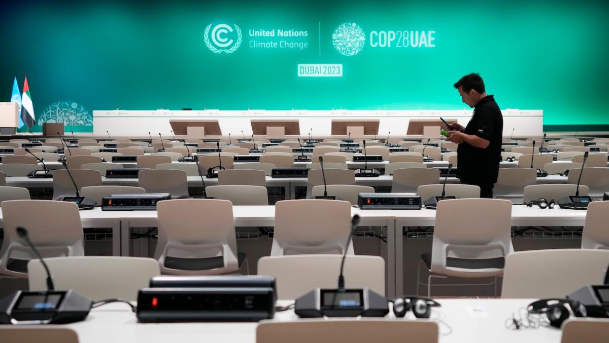 A worker sets up in a room a full of empty chairs and microphones ahead of the COP28 U.N. Climate Summit, Wednesday, Nov. 29, 2023, in Dubai, United Arab Emirates.