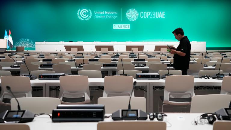 A worker sets up in a room a full of empty chairs and microphones ahead of the COP28 U.N. Climate Summit, Wednesday, Nov. 29, 2023, in Dubai, United Arab Emirates.