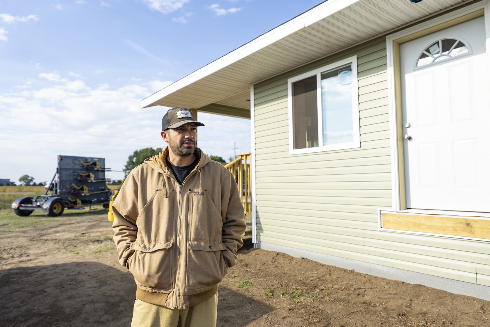 Danny Desjarlais, the project manager for the hempcrete effort, stands next to a newly built duplex made with the tribe's hempcrete.