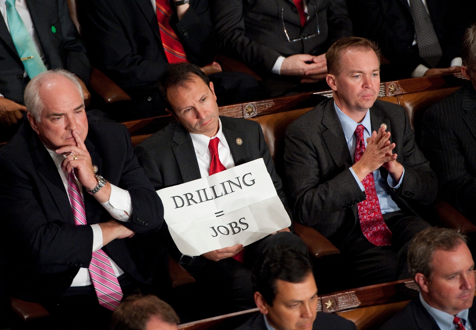 Jeff Landry, then a member of Congress, holds up a sign that reads "DRILLING = JOBS" during an address by then-President Barack Obama in 2011. Landry defended the oil industry in the aftermath of the Deepwater Horizon spill.