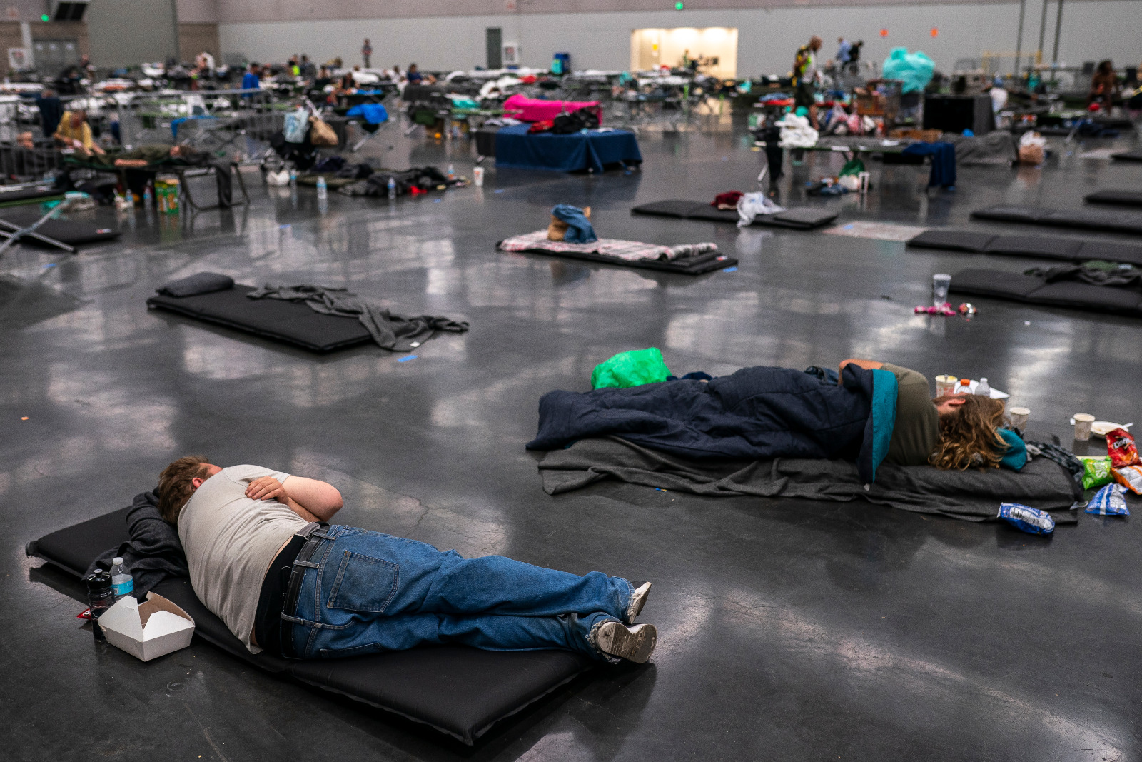 Photo of people lying down on mats on the floor of a large room