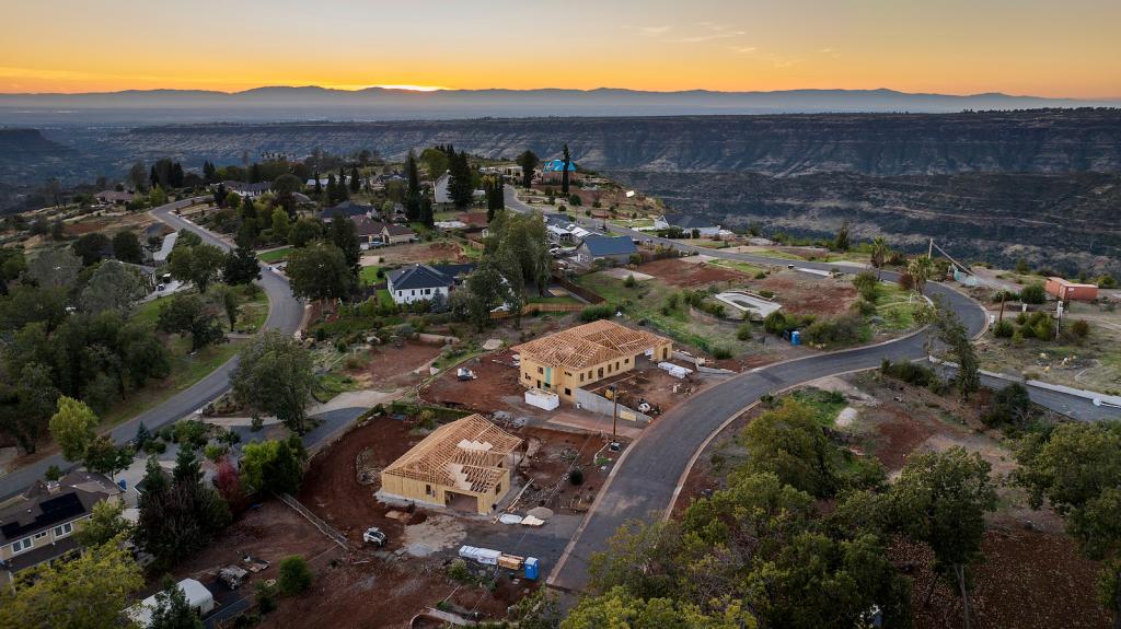 Empty lots, homes under construction and residences built after the Camp Fire line the street.