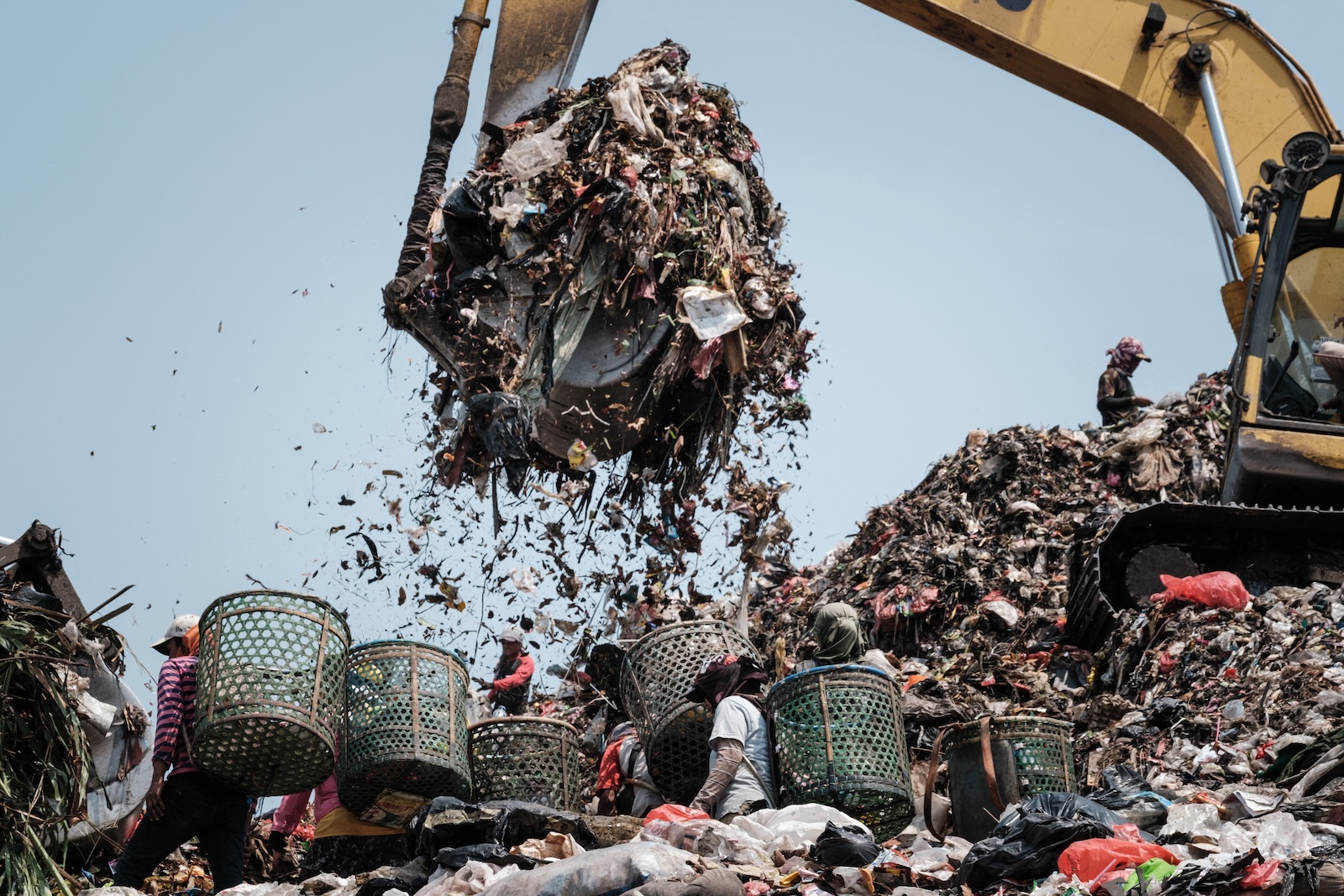 A crane lifts trash in a landfill