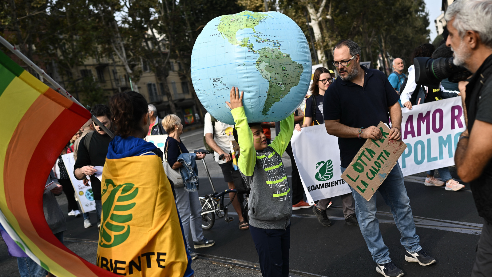 Photo of a child holding an inflatable earth over his head during a demonstration
