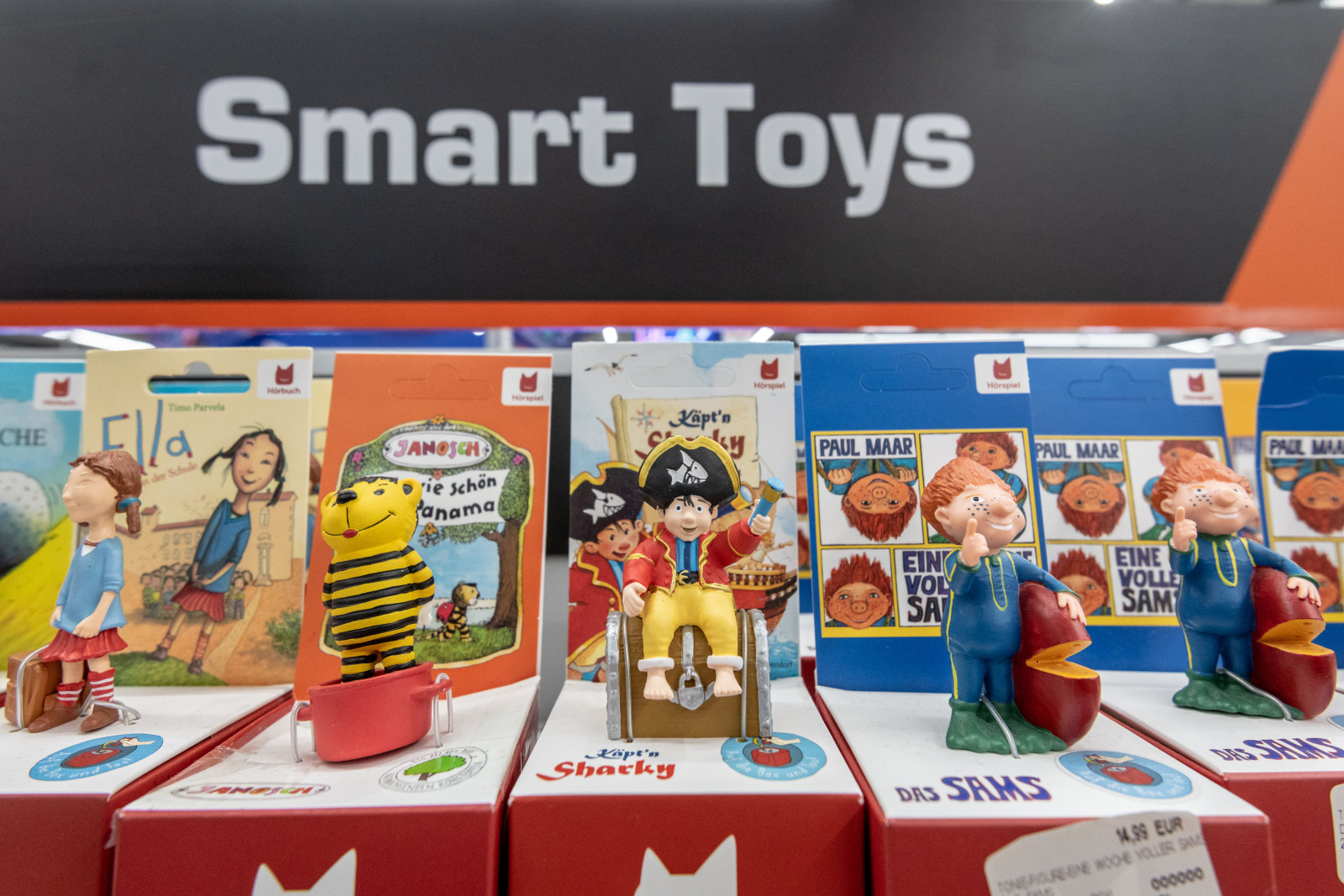 A sign that says "Smart Toys" is seen above a display of five colorful toy figurines