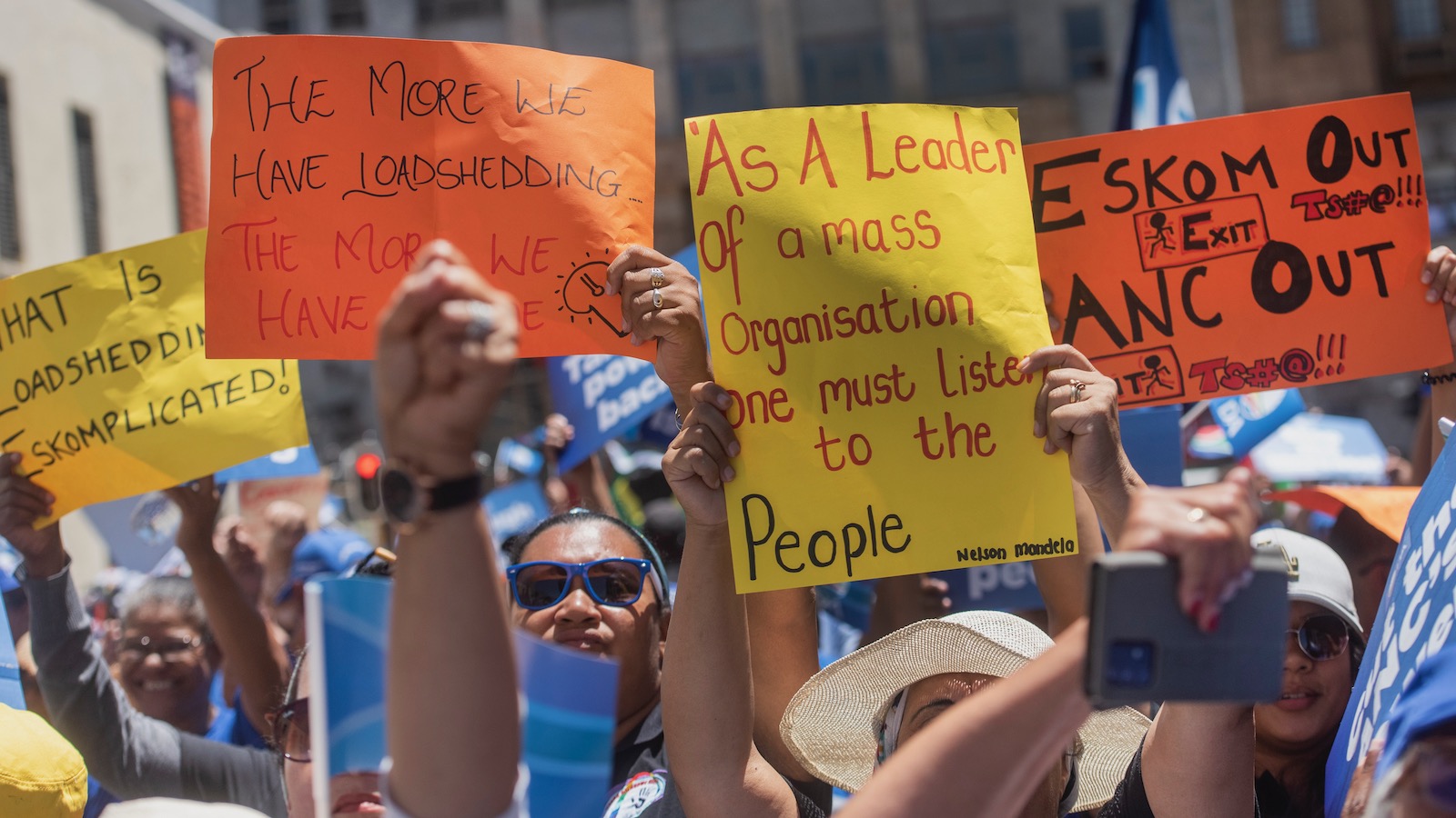 Protestors waving colorful signs rally in Cape Town to protest ongoing electricity outages prompted by the nation's aging coal-fired power plants.