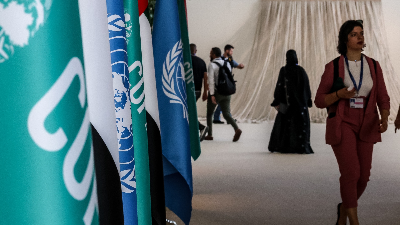 Participants walk by United Nations, United Arab Emirates and COP28 flags during the COP28 climate summit in Dubai.