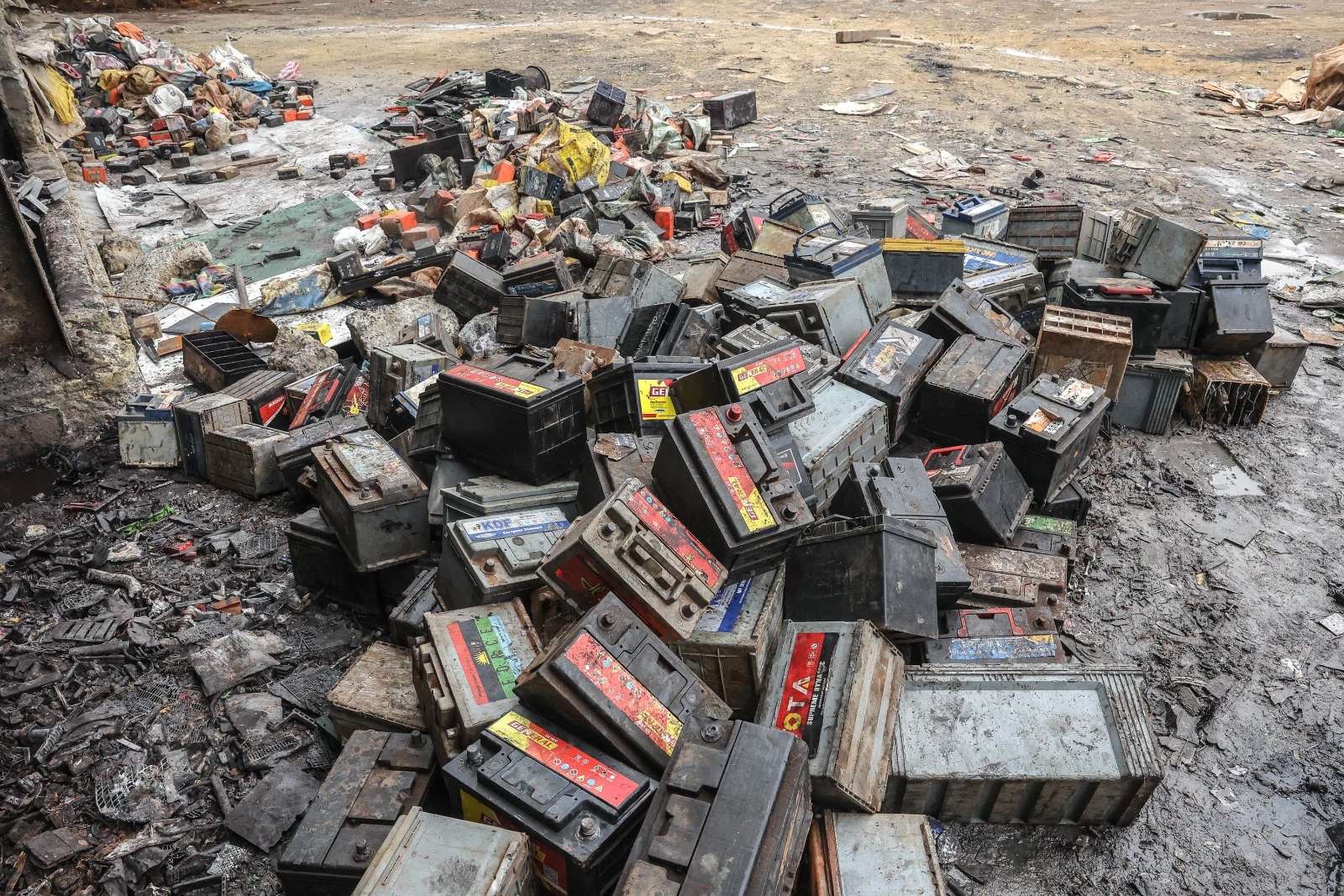 A huge pile of black boxes are scattered on the ground.