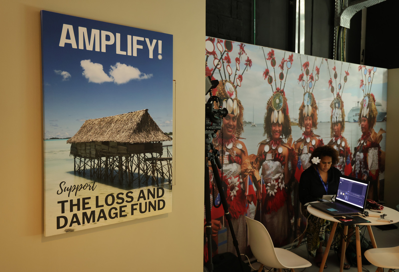 a poster with a house near the ocean says amplify support the loss and damage fund