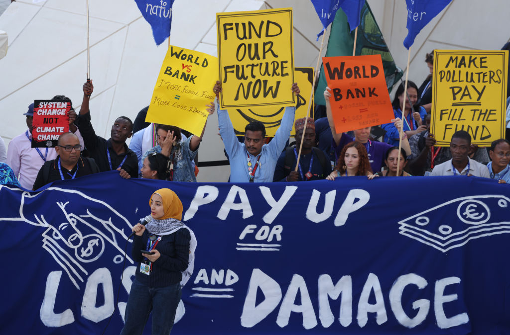 Protesters stand behind banner that reads 