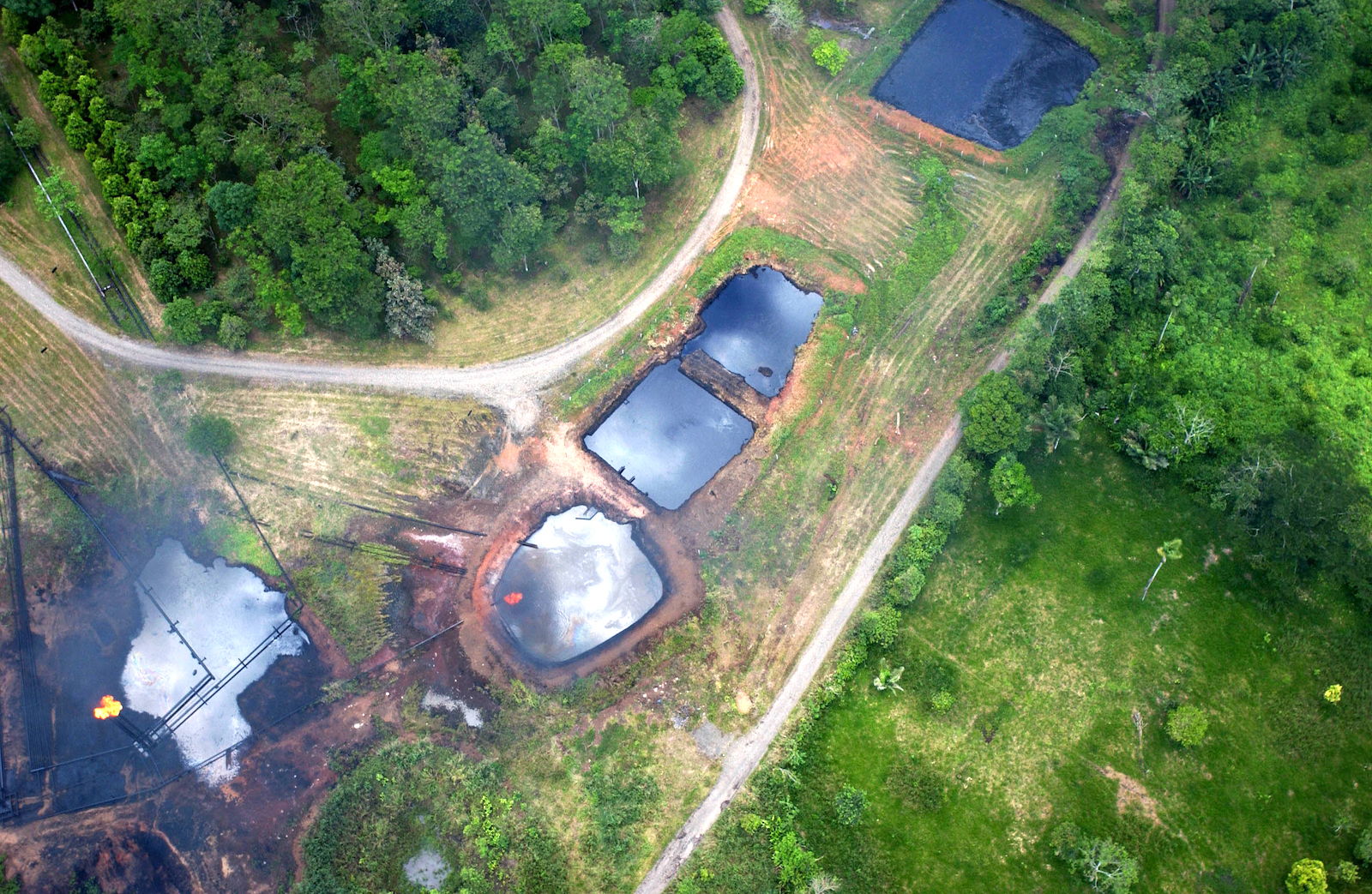 large oil slick pools amid forest as seen from an aerial view