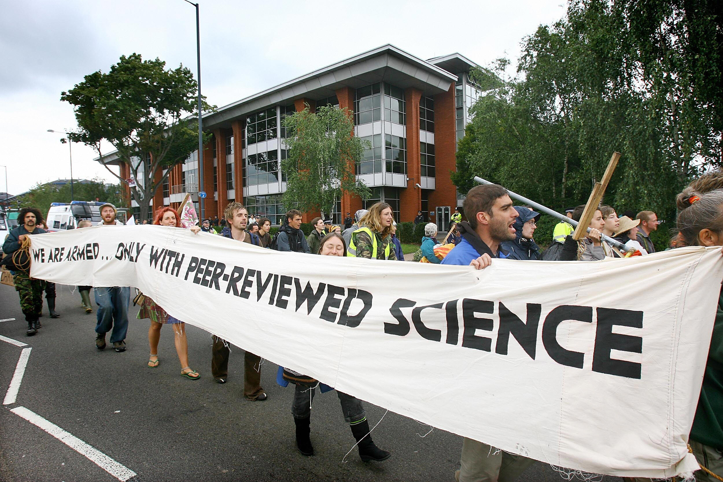 Photo of protesters holding a sign that says armed only with peer-reviewed science