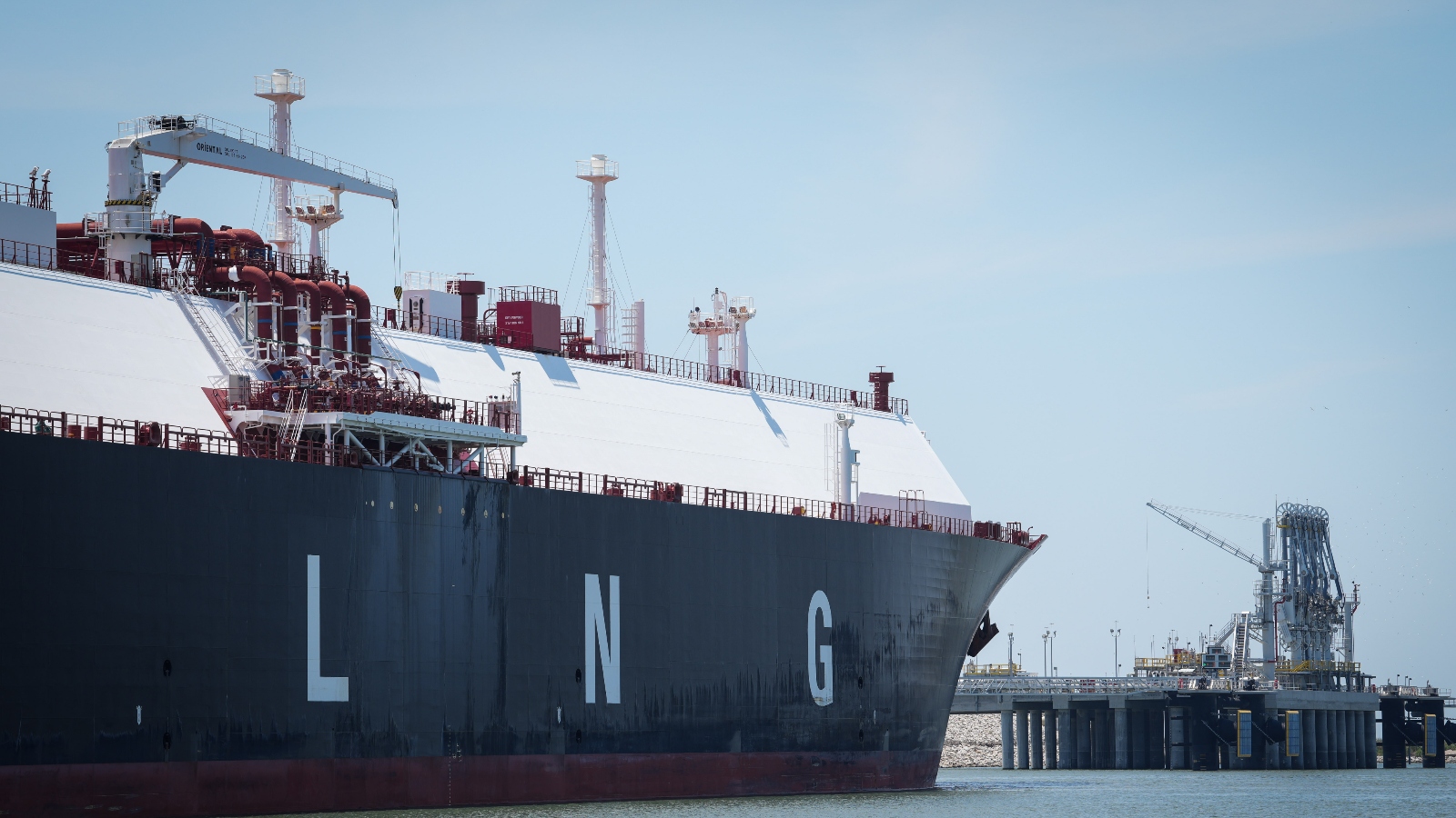 A large liquefied natural gas tanker sits docked in the Calcasieu River in June 2023, near the site of Venture Global's LNG export terminal.