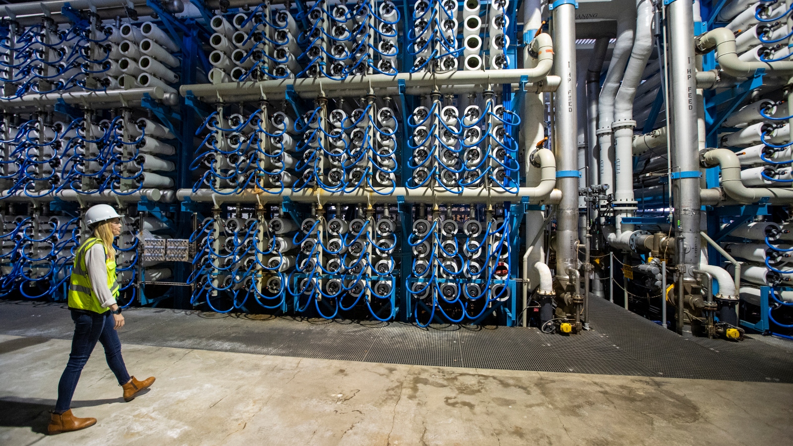 A technician walks past reverse osmosis membranes at a desalination plant in Carlsbad, California.