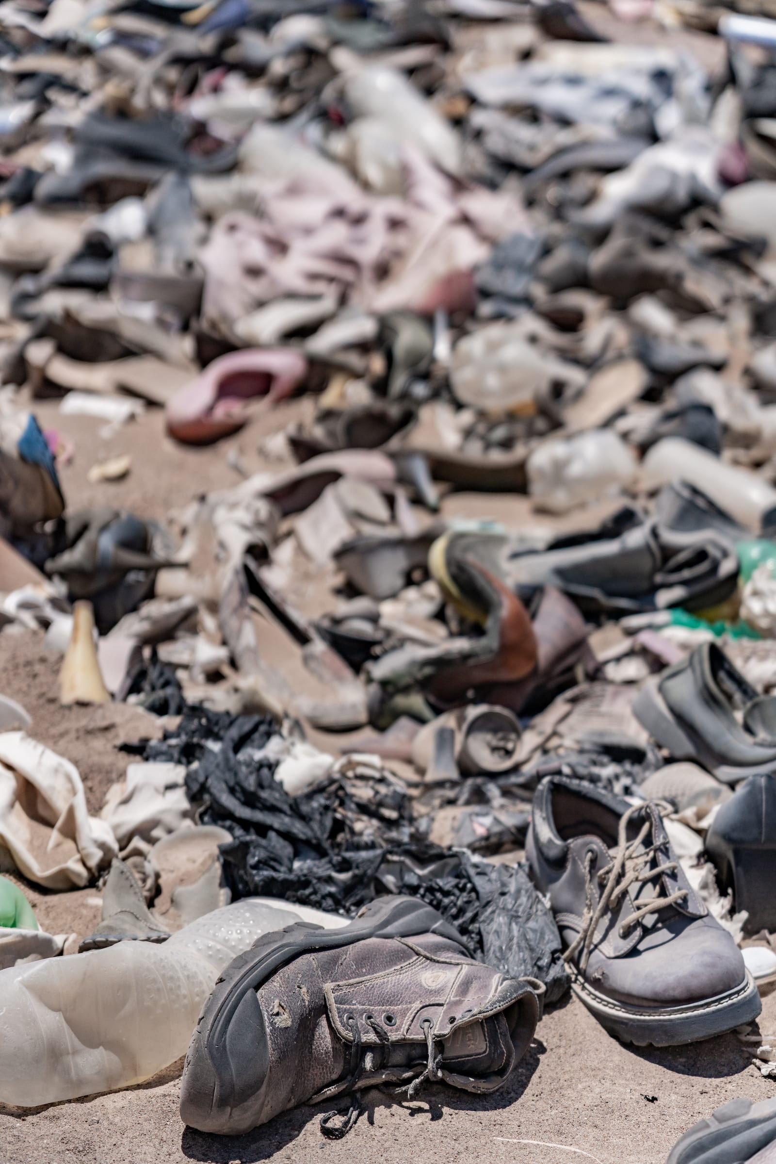 old shoes in a dense pile in the desert