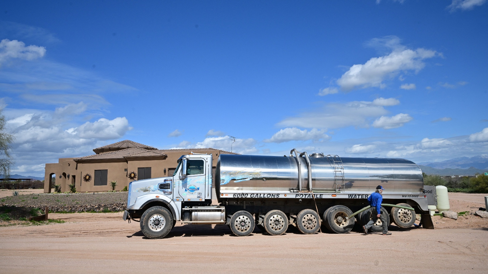 John Hornewer delivers water from his truck to a residential water tank in Rio Verde Foothills, Arizona. The neighborhood lost its water access last year as the Colorado River drought worsened.