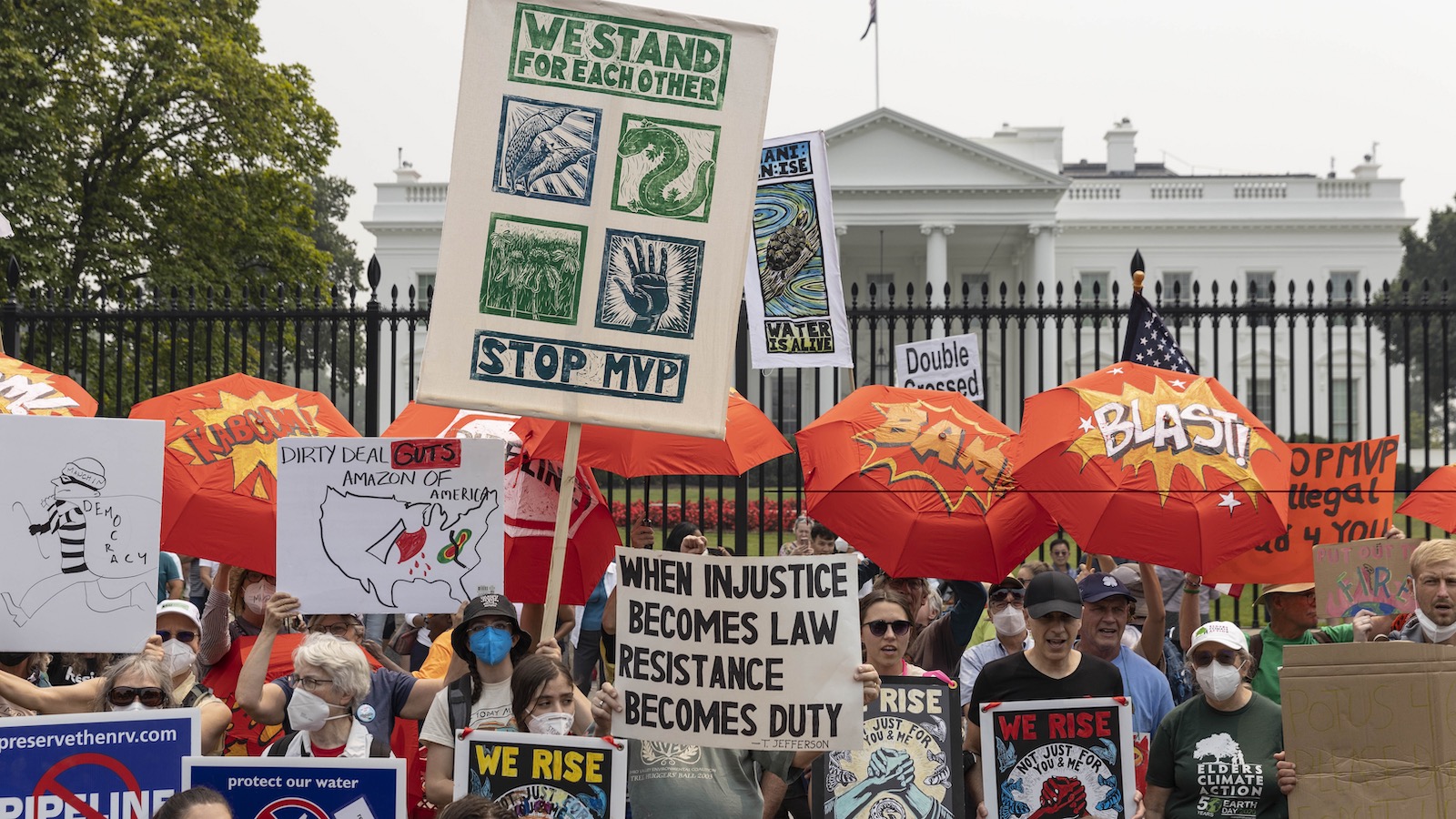 A crowd of protesters with Stop Mountain Valley Pipeline rally and wave pickets in front of the White House.