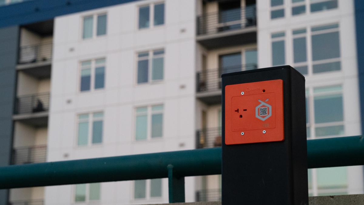 An EV charging outlet in front of an apartment building