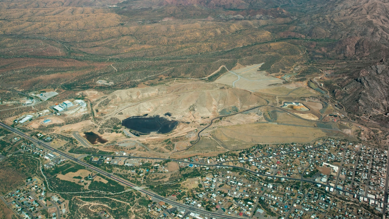 An aerial view of a mining pit next to a town.