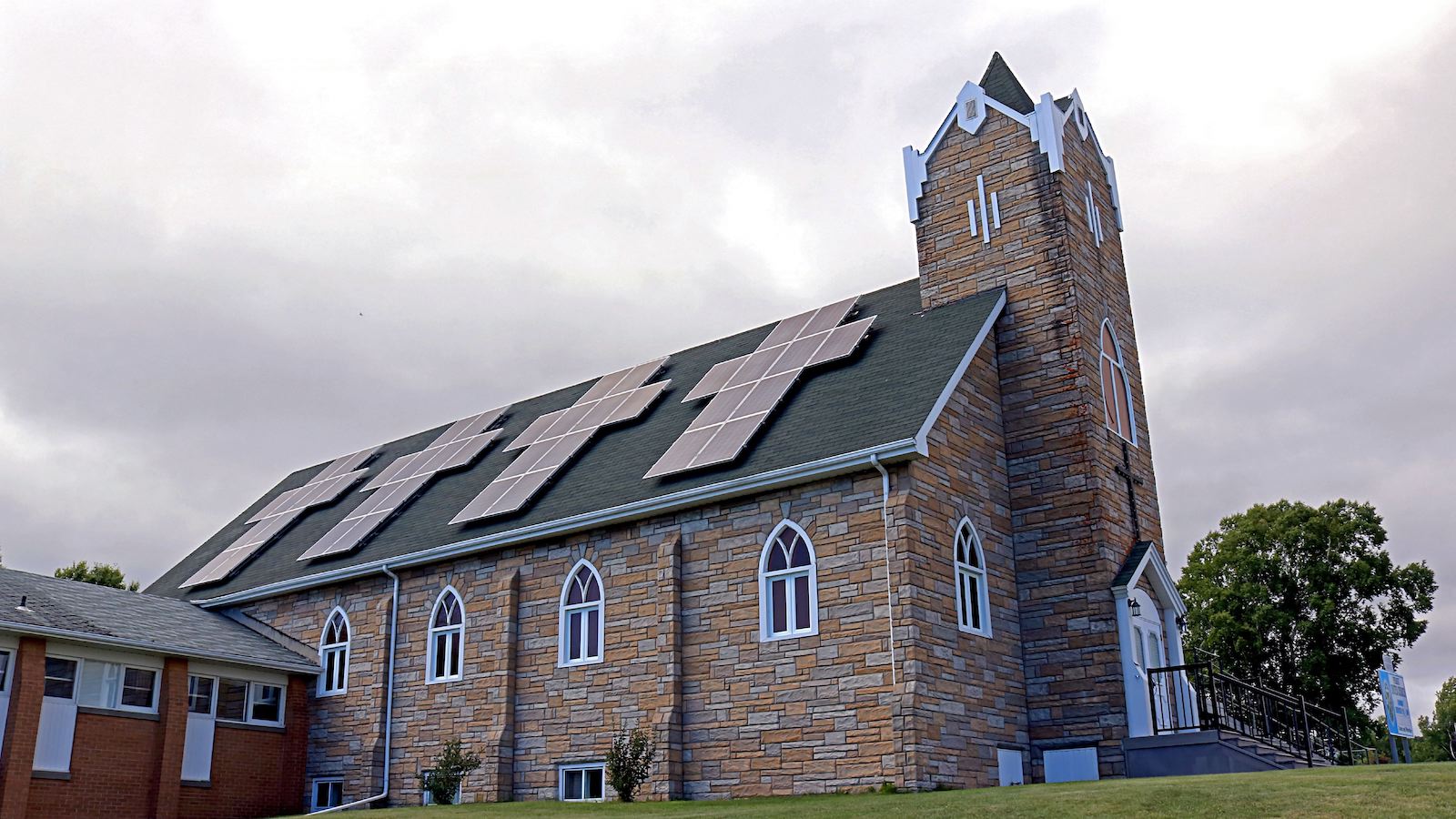 solar panels in the forms of crosses installed on the slanted roof of a Christian church