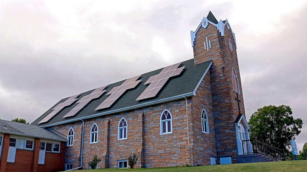 solar panels in the forms of crosses installed on the slanted roof of a Christian church