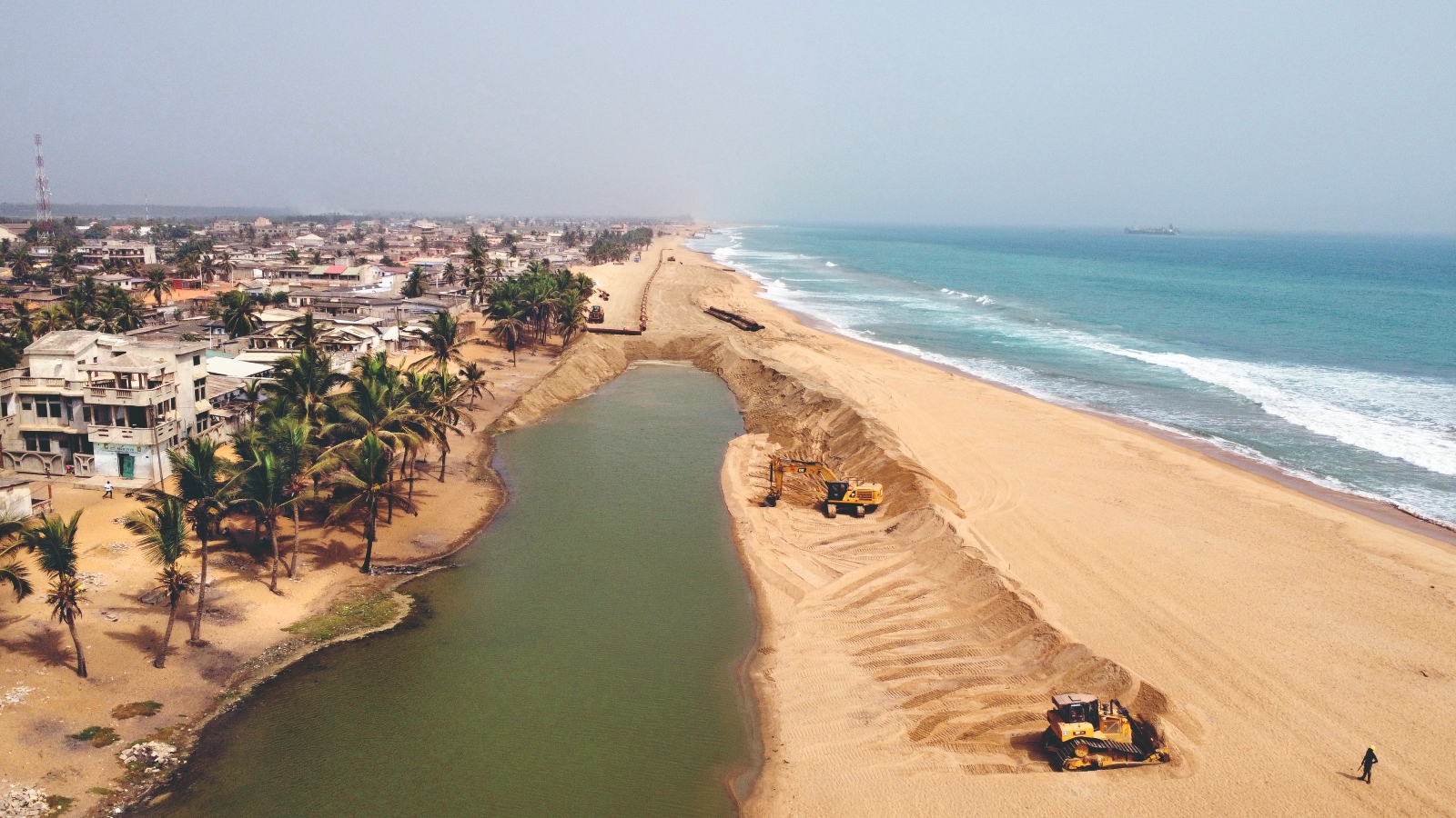 Construction crews move sand to build a sand motor on the coast of Benin, in West Africa. The country is facing rapid erosion as a result of sea level rise.