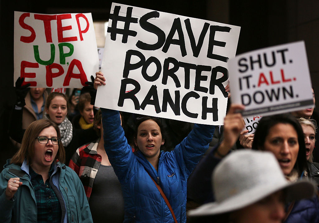 A group of protestors hold up signs that say Save Porter Ranch and Step up EPA
