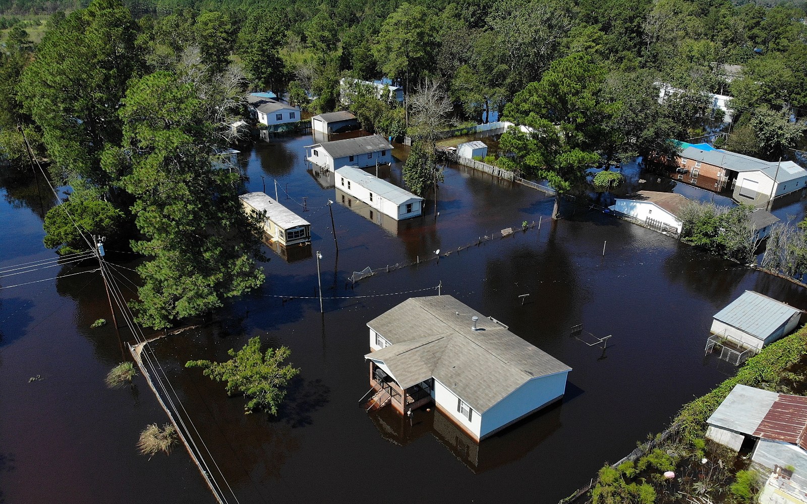 Photo of homes submerged in dark water.
